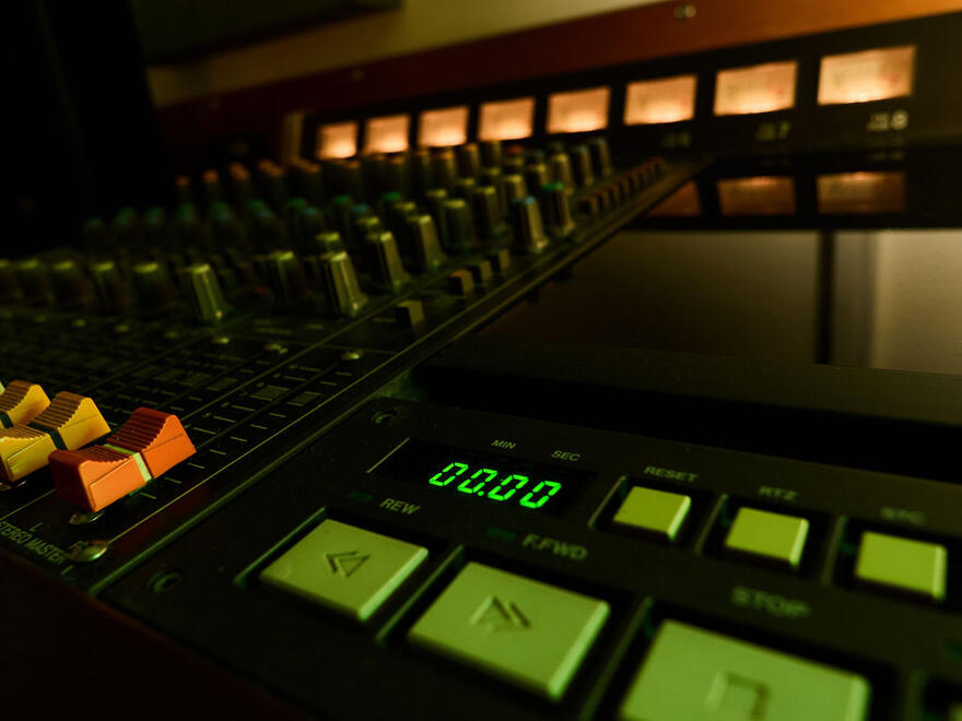 Mixing-console faders and illuminated tape transport controls. Mixing-console faders and illuminated tape transport controls.